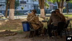 Ukrainian soldiers eat at an outdoor area of a restaurant in Kramatorsk, Ukraine, Sept. 13, 2023.