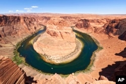 FILE - The Colorado River flows at Horseshoe Bend in the Glen Canyon National Recreation Area in Page, Arizona, on June 8, 2022.