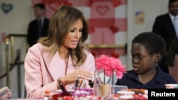 FILE - US first lady Melania Trump makes candygrams with 13-year-old sickle cell disease sufferer Amani during a Valentine’s Day visit with young patients at the National Institutes of Health (NIH) in Bethesda, Maryland, Feb. 14, 2019.