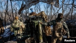 Servicemen of the 12th Special Forces Brigade Azov of the National Guard of Ukraine prepare to fire from a howitzer LH-70 towards Russian troops at a position near a frontline, Ukraine, Nov. 22, 2023.