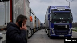 FILE - Trucks wait to cross the Ukraine-Poland border, as Russia's attack on Ukraine continues, at the checkpoint Rava-Ruska, Lviv region, Ukraine, April 17, 2023.