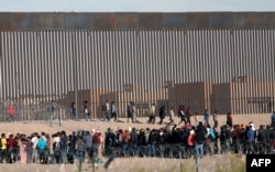 Migrants seeking asylum wait to be processed by the U.S. Border Patrol after having crossed the Rio Grande River from Ciudad Juarez, Mexico, on Dec. 5, 2023.