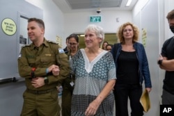 FILE - Released Israeli hostage Margalit Moses walks with an Israeli soldier upon her arrival in Israel on Nov. 24, 2023, after being held hostage by Hamas in Gaza. (Israel Defense Forces via AP)