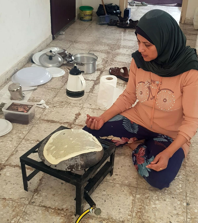 Hala baking bread in the apartment where she and her family are displaced in Rafah.