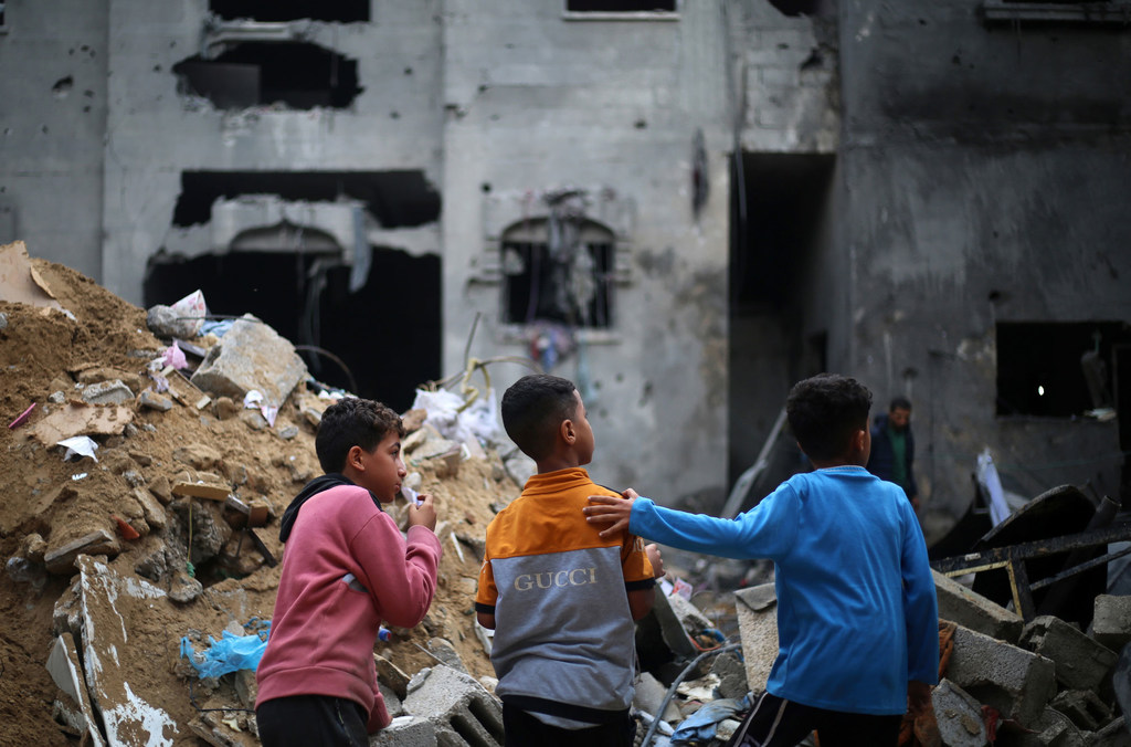 Children look at their destroyed homes in Rafah city, in the southern Gaza Strip. 