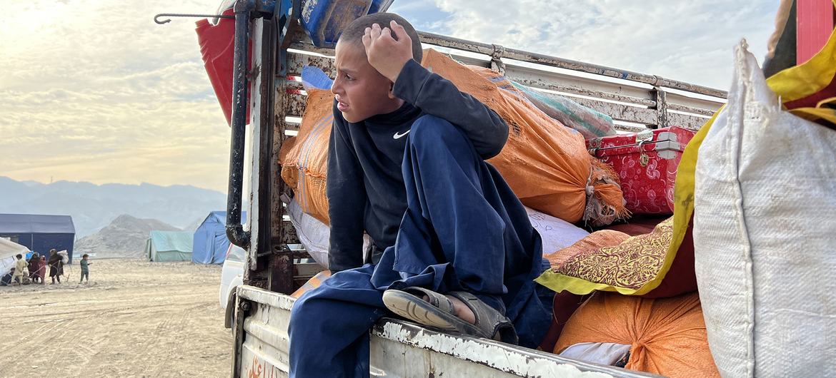 A boy in a truck carrying his family's possessions waits to return to Afghanistan.
