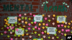 Notes from students expressing support and sharing coping strategies paper a wall, as members of the Miami Arts Studio mental health club raise awareness on World Mental Health Day, Oct. 10, 2023,