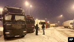 Ukrainian truck drivers wait to cross from Poland back into Ukraine in Korczowa, Poland, on Dec. 7, 2023.