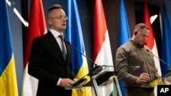 Hungary's foreign minister Peter Szijjarto, left, speaks during a press conference with his Ukrainian counterpart Dmytro Kuleba in Kamianytsia, Ukraine, Jan. 29, 2024.