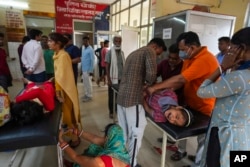 FILE - People suffering from heat-related ailments crowd the district hospital in Ballia, Uttar Pradesh state, India, on June 20, 2023.