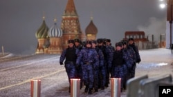 FILE - Police and Rosgvardia (National Guard) servicemen walk on the Red Square with St. Basil's Cathedral in the background, in Moscow, Russia, Dec. 31, 2023.