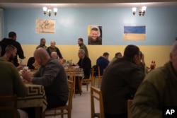 FILE - Wounded soldiers, including a group of Colombian army veterans who joined the Ukrainian armed forces to help the country fight Russia, have lunch in a hospital in Ukraine, Dec. 20, 2023.