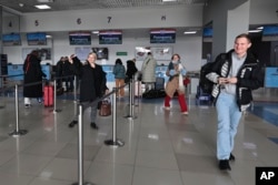 Members of the first group of Russian tourists walk after checking-in to board a plane to fly to North Korea at the international airport outside in Vladivostok, Russia's Far East region of Primorsky Krai, Feb. 9, 2024.