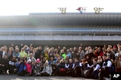 A group of Russian tourists, likely the first foreign travelers from any country to enter North Korea since the pandemic pose for a group photo on the arrival at the Pyongyang International Airport in Pyongyang, North Korea, Feb. 9, 2024.