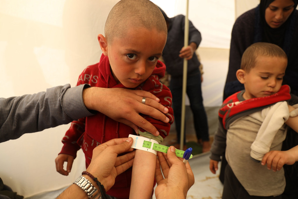 Mohammad is getting measured as part of a malnutrition screening at a UNICEF-supported pediatrician clinic tent in Rafah in southern Gaza.