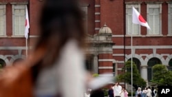 FILE - Tourists walk pat Tokyo Station, May 26, 2023, in Tokyo.