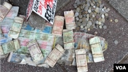 Discarded bills and coins of Zimbabwe's old currency are seen on the pavement of a street in Harare, April 15, 2024. (Columbus Mavhunga/VOA)