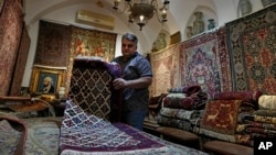 Iranian carpet shop owner Ali Faez works at his shop at the traditional bazaar of the city of Kashan, Iran, about 245 kilometers south of the capital, Tehran, April 30, 2024.