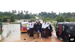 Schoolchildren are stranded on a damaged River Zingiziwa bridge in Dar Esalaam, Tanzania, on April 25, 2024. Flooding in Tanzania caused by weeks of heavy rain has killed at least 150 people as of May 4, 2024, and affected hundreds of thousands more.