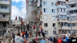 In this photo from video released by the Russian Emergency Ministry Press Service, Russian emergency services work at the scene of a partially collapsed apartment building in Belgorod, Russia, May 12, 2024.