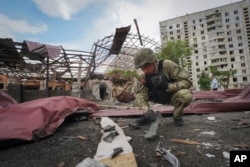 FILE - A sapper inspects fragments of a Russian bomb that hit a living area, injuring 10 in Kharkiv, Ukraine, May 22, 2024. Kyiv is struggling to hold off Russian advances in the Kharkiv region.