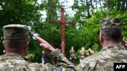 Ukrainian servicemen attend a ceremony at the site of the former Stalag 328 camp in Lviv on May 8, 2024, to mark the Day of Remembrance and Reconciliation, and the 79th anniversary of the victory over Nazism and the end of the World War II in Europe.