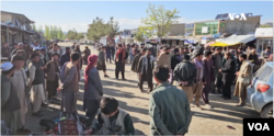 Residents of Argo, Afghanistan, gather after clashes with Taliban forces that killed two people.