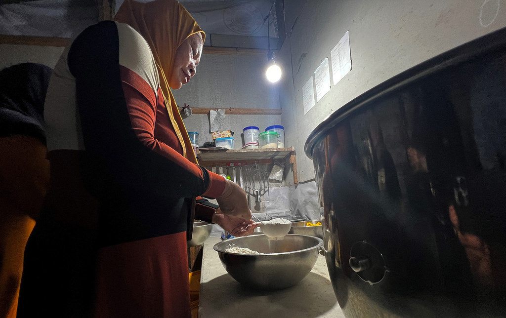 A cooperative member prepares a cake recipe.