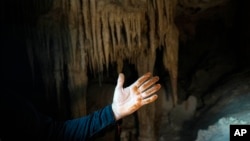 Engineer Guillermo D. Christy shows his hand stained with rust after touching a steel pillar in the Aktun Tuyul cave system. Construction of the Maya Train is rapidly destroying much of the hidden underground world of caverns and sinkhole lakes.