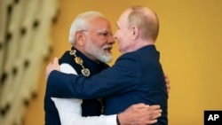 Russian President Vladimir Putin, right, and Indian Prime Minister Narendra Modi embrace after Putin awarded Modi with the Order of St. Andrew the Apostle, at the Kremlin in Moscow, July 9, 2024.