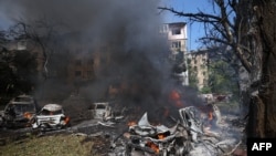 This photograph taken on July 8, 2024 shows burning cars at the site of a missile attack in Kyiv, Ukraine.