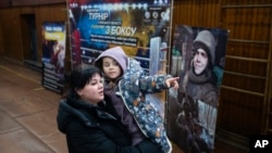 Vasilisa plays with her mother, Polina Ihrak, during a boxing tournament in honor of her father, Maksym Halinichev, who was killed during fighting with Russian forces in March 2023, in Romny, in Ukraine's Sumy region, Feb. 3, 2024.