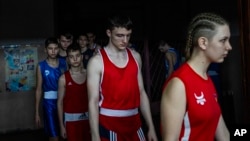 Young boxers enter the opening ceremony of a boxing tournament in honor of Maksym Halinichev, in Romny, in Ukraine's Sumy region, Feb. 3, 2024.