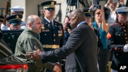 FILE - Defense Secretary Lloyd Austin, right, greets Ukraine's Defense Minister Rustem Umerov during an arrival ceremony at the Pentagon, near Washington, July 2, 2024.