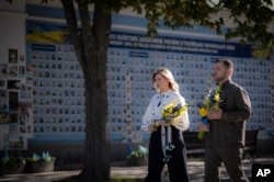 In this photo provided by the Ukrainian Presidential Press Office, Ukrainian President Volodymyr Zelenskyy and his wife, Olena, visit the Memorial Wall of Fallen Defenders of Ukraine on Independence Day in Kyiv on Aug. 24, 2024.