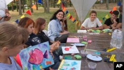 First lady Olena Zelenska talks with children during her visit to the rehabilitation camp "Loud Camp" for children affected by war in Uzhhorod, Ukraine, Aug. 27, 2024.