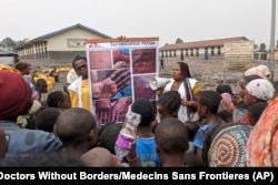 This photo supplied by MSF (Doctors Without Borders) shows health workers educating children in Goma, Congo, on the symptoms of mpox disease, May 31, 2023.