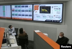 Employees look on the monitors displaying Japan's Nikkei share average, which has had a record breaking-drop in the closing price, at Nagoya Stock Exchange in Nagoya, Japan, Aug. 5, 2024. (Kyodo via Reuters)