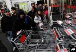 FILE - Shoppers rush into a Kmart store in Chicago on Nov. 25, 2011, for the Black Friday sale.