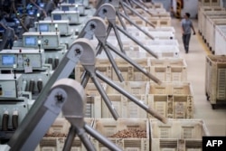 An employee passes by baskets full of corks at the Amorim cork factory in Mozelos, near Santa Maria da Feira, north of Portugal on Sept. 10, 2024.