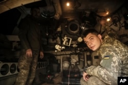 In this photo provided by Ukraine's 24th Mechanised Brigade press service, Ukrainian soldiers are seen inside a M109 self-propelled howitzer in Chasiv Yar, Donetsk region, Ukraine, Oct. 23, 2024. (Oleg Petrasiuk/Ukrainian 24th Mechanised Brigade via AP)