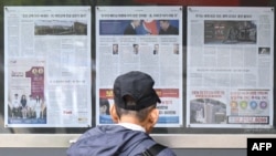 FILE - A man walks past a newspaper displayed on a street for the public in Seoul on Oct. 21, 2024, with coverage on North Korea's decision to deploy thousands of soldiers to Ukraine's front lines.