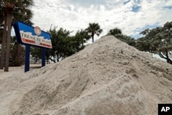 FILE - Sand washed ashore by the surge of Hurricane Helene is piled in Treasure Island, Florida, Oct. 2, 2024.