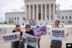 FILE - Katie Mahoney, left, and the Rev. Patrick Mahoney, chief strategy officer for Stanton Healthcare, an Idaho-based pregnancy center that does not provide abortions, read the text of a Supreme Court decision outside the court in Washington, June 27, 2024.