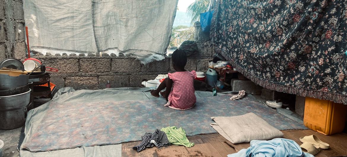 A young child whose family fled violence sits in a makeshift shelter in Port-au-Prince.