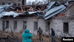 FILE - Residents walk at the site of a Russian missile strike, amid Russia's attack on Ukraine, in Dnipro, Ukraine, Nov. 21, 2024.