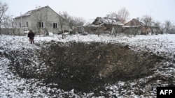 Yaroslava Sukach, 77, a local resident whose house was destroyed, stands next to a crater following a missile strike on the village of Sknyliv, some 60km from Lviv, on Jan. 15, 2025.