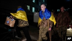 Ukrainian serviceman Yevhen Liashenko uses crutches as he arrives to be reunited with his wife after returning from Russian captivity, during a prisoner of war exchange at an unidentified location in Ukraine, Dec. 30, 2024.