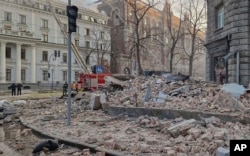 A view of debris on a street from nearby buildings, hundreds of meters from Ukraine's Presidential Office, after a Russian drone attack in Kyiv, Ukraine, Jan. 1 2025.