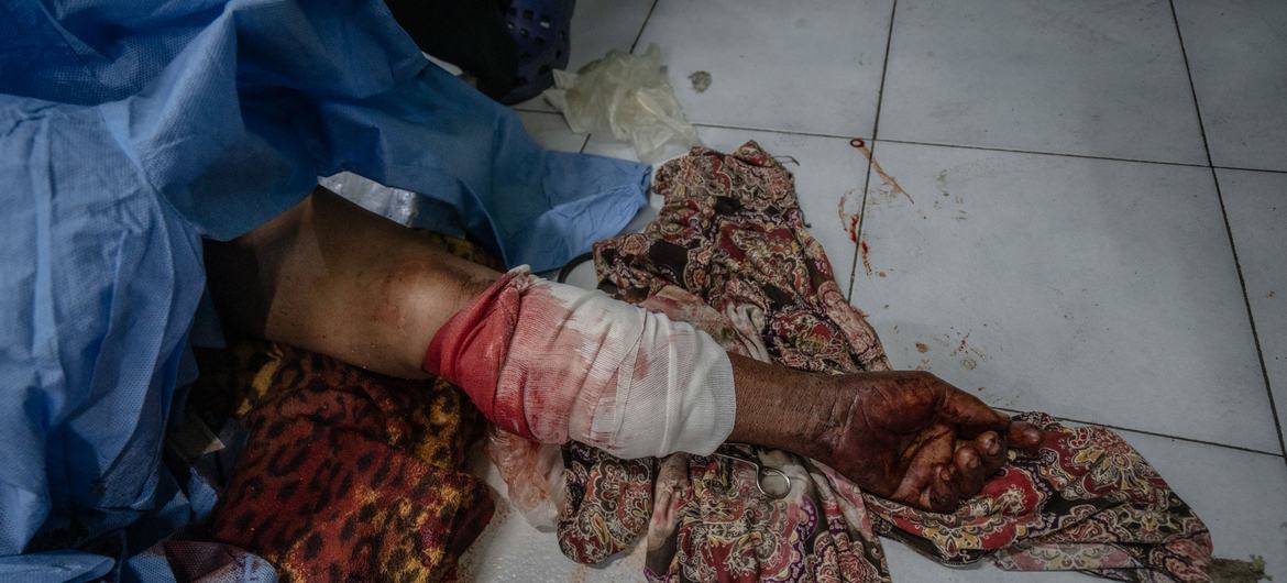 A 63-year-old woman lies wounded on the floor of a hospital in Port-au-Prince after warring gangs swept through her neighborhood.